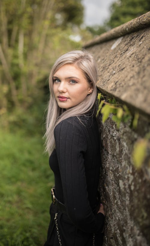 Photo of a Woman in a Black Long Sleeve Top Looking at the Camera