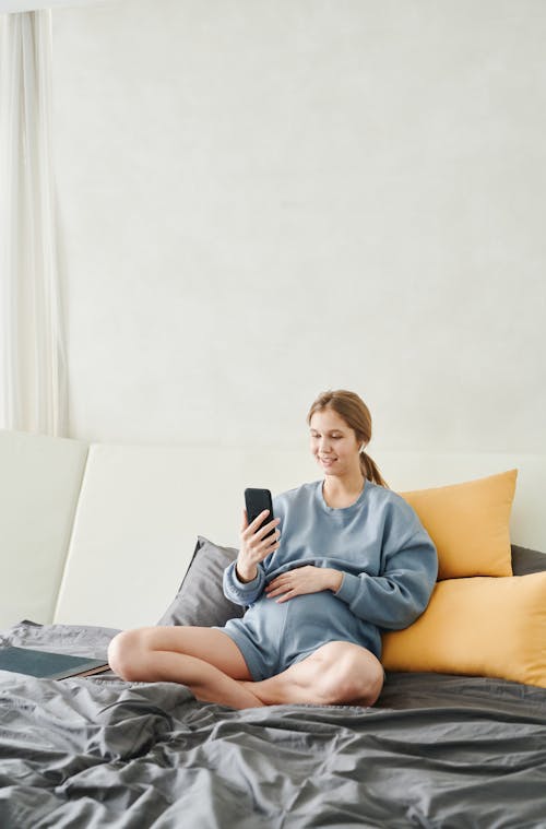 Free Pregnant Woman Sitting on Bed Stock Photo