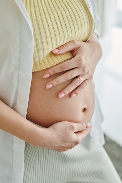 Free Pregnant Woman Holding Her Baby Bump Stock Photo