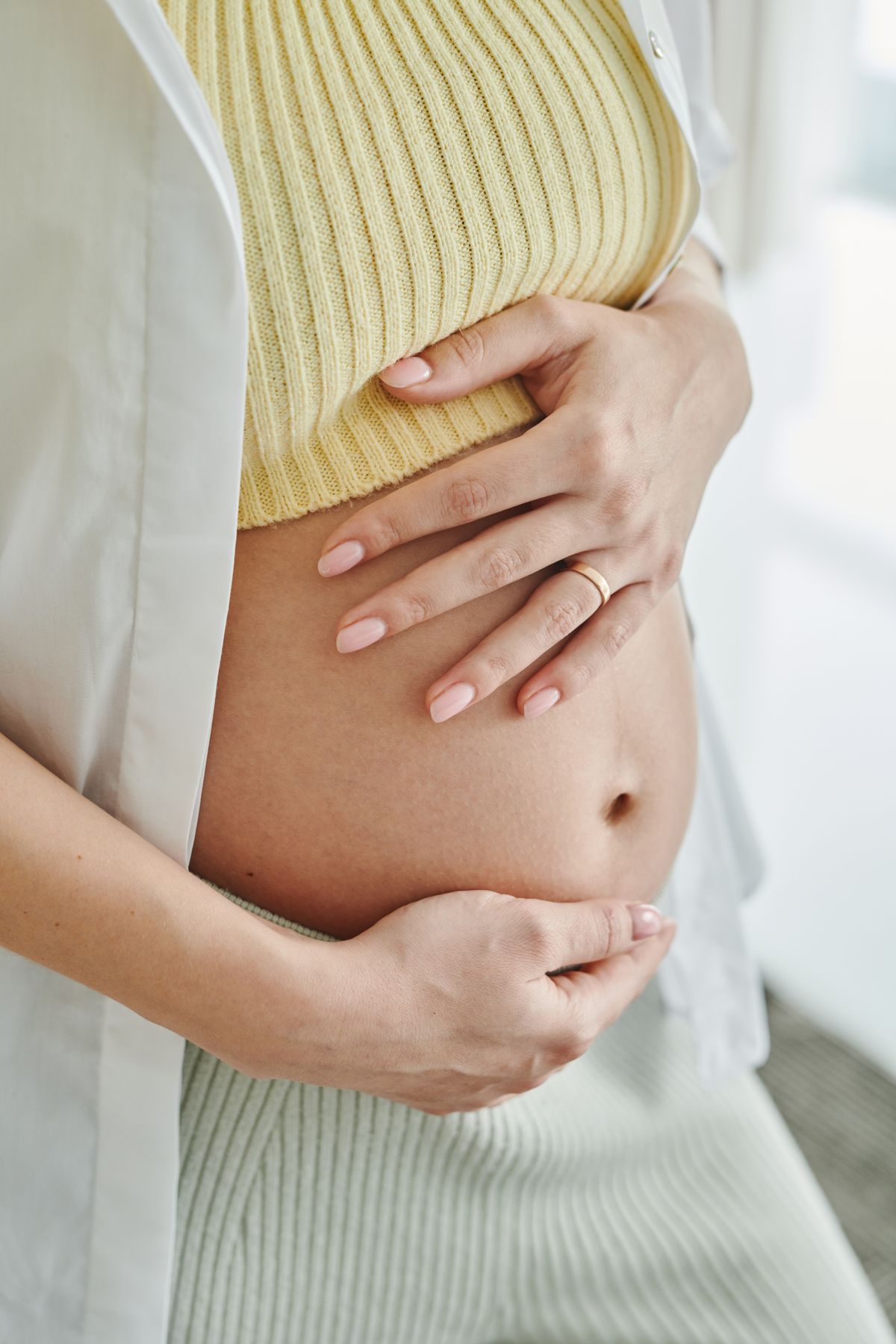 Pregnant mother gently holding her belly
