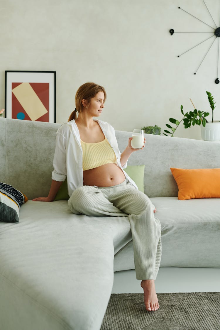 A Pregnant Woman Holding A Glass Of Milk