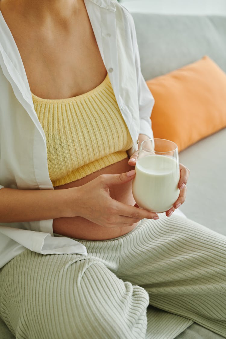 A Person Holding A Glass Of Milk