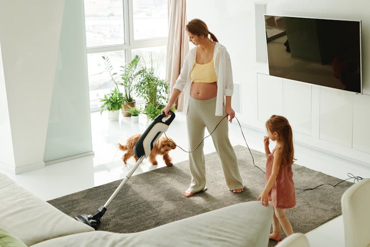 A Woman Using A Vacuum