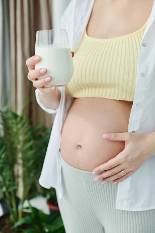 A Pregnant Woman Holding a Glass of Milk