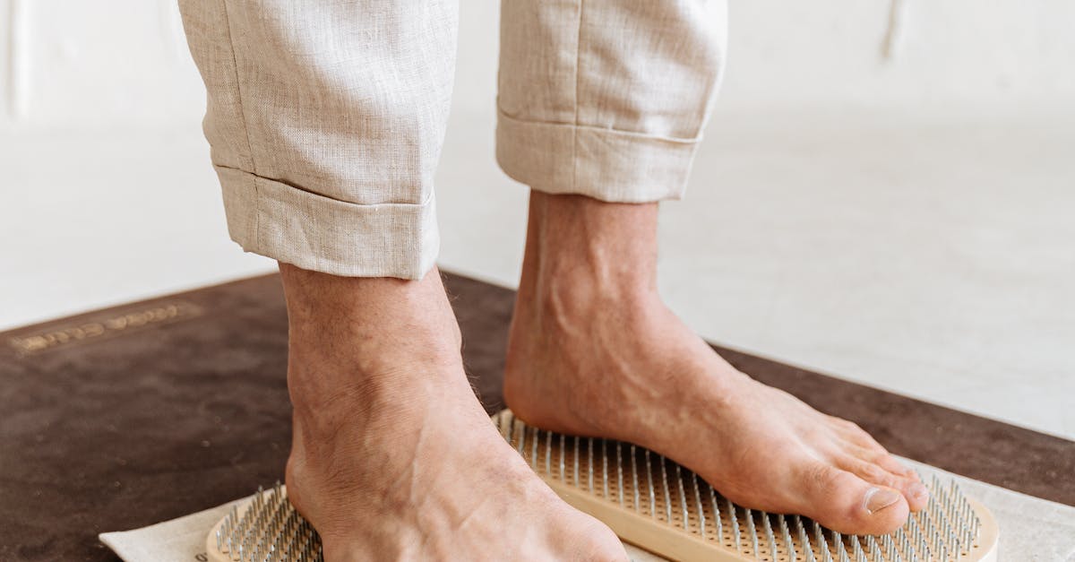 A close-up of a person barefoot on an acupressure mat for alternative therapy.