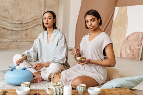 Free Women Sitting on the Floor while Doing Meditation Stock Photo