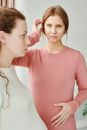 Woman in Pink Long Sleeve Shirt Holding Woman in White Long Sleeve Shirt