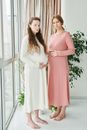 Woman in Pink Long Sleeve Dress Standing Beside Green Plant