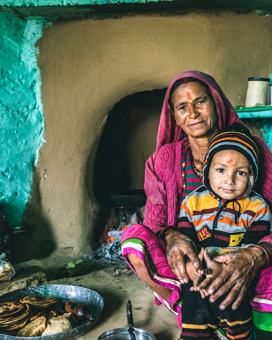 Ek maa apni rasoi mein roti belte hue