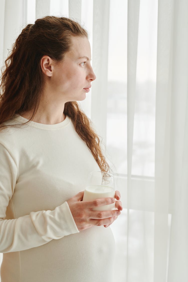 Photo Of A Pregnant Woman Holding A Glass Of Milk