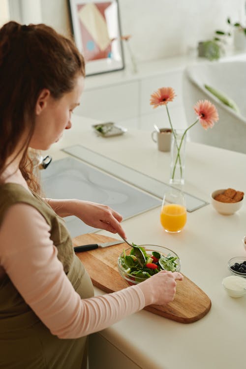 A Pregnant Woman Preparing a Vegetable Salad