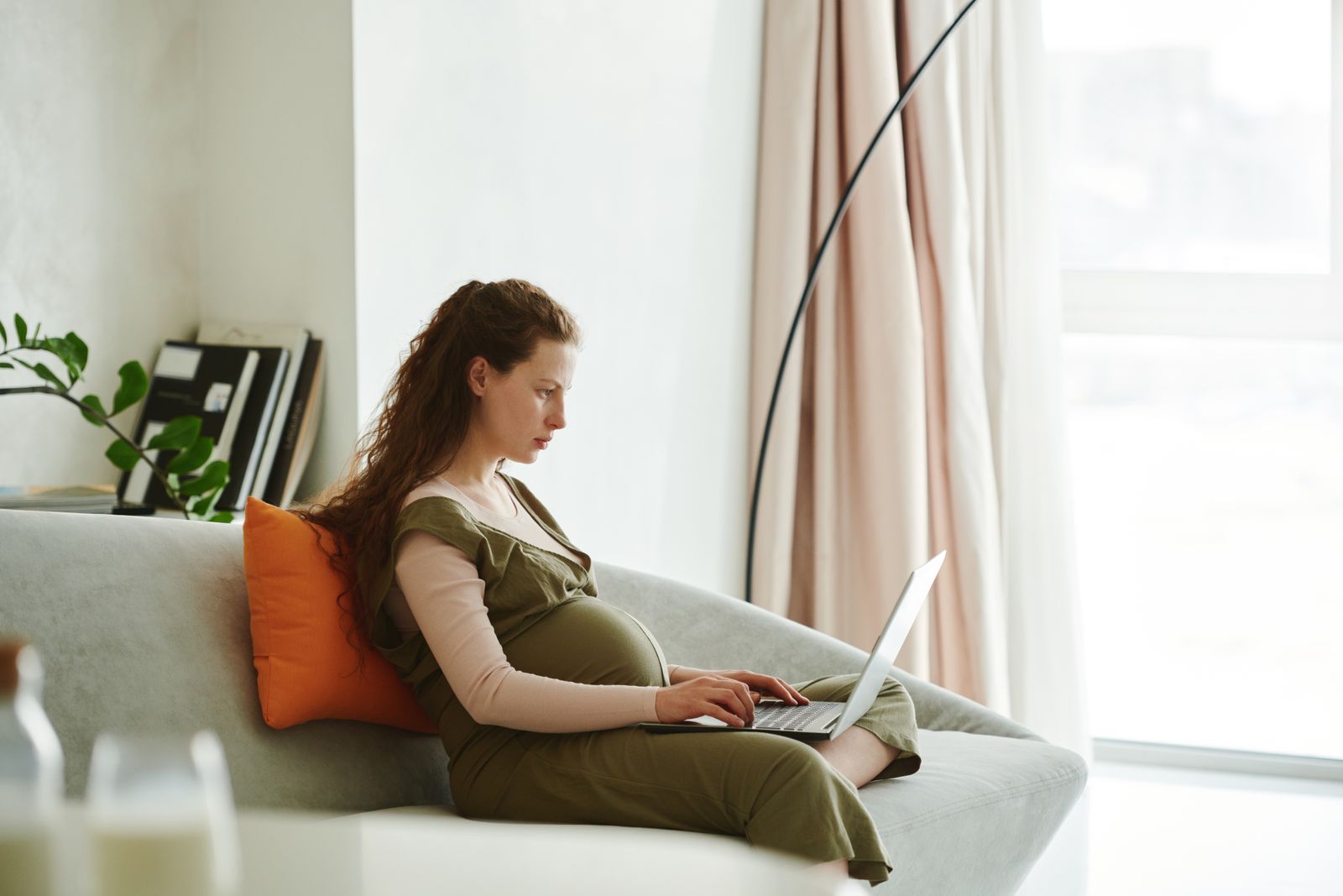 Gestante trabalhando em notebook em casa