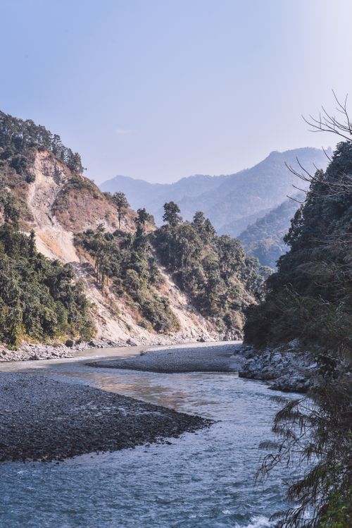 Free Captivating view of a tranquil river winding through lush Himalayan mountains in Sikkim, India. Stock Photo