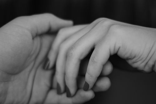 Free A touching monochrome image of two hands gently holding each other, symbolizing connection. Stock Photo