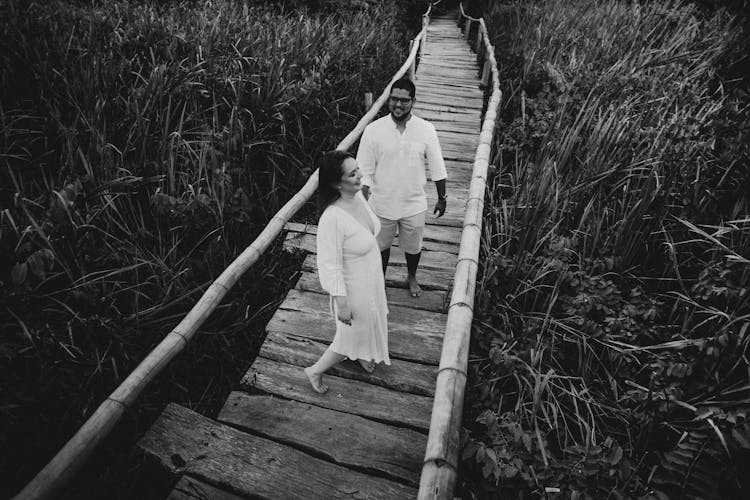 Smiling Couple On Old Bridge Above Grass