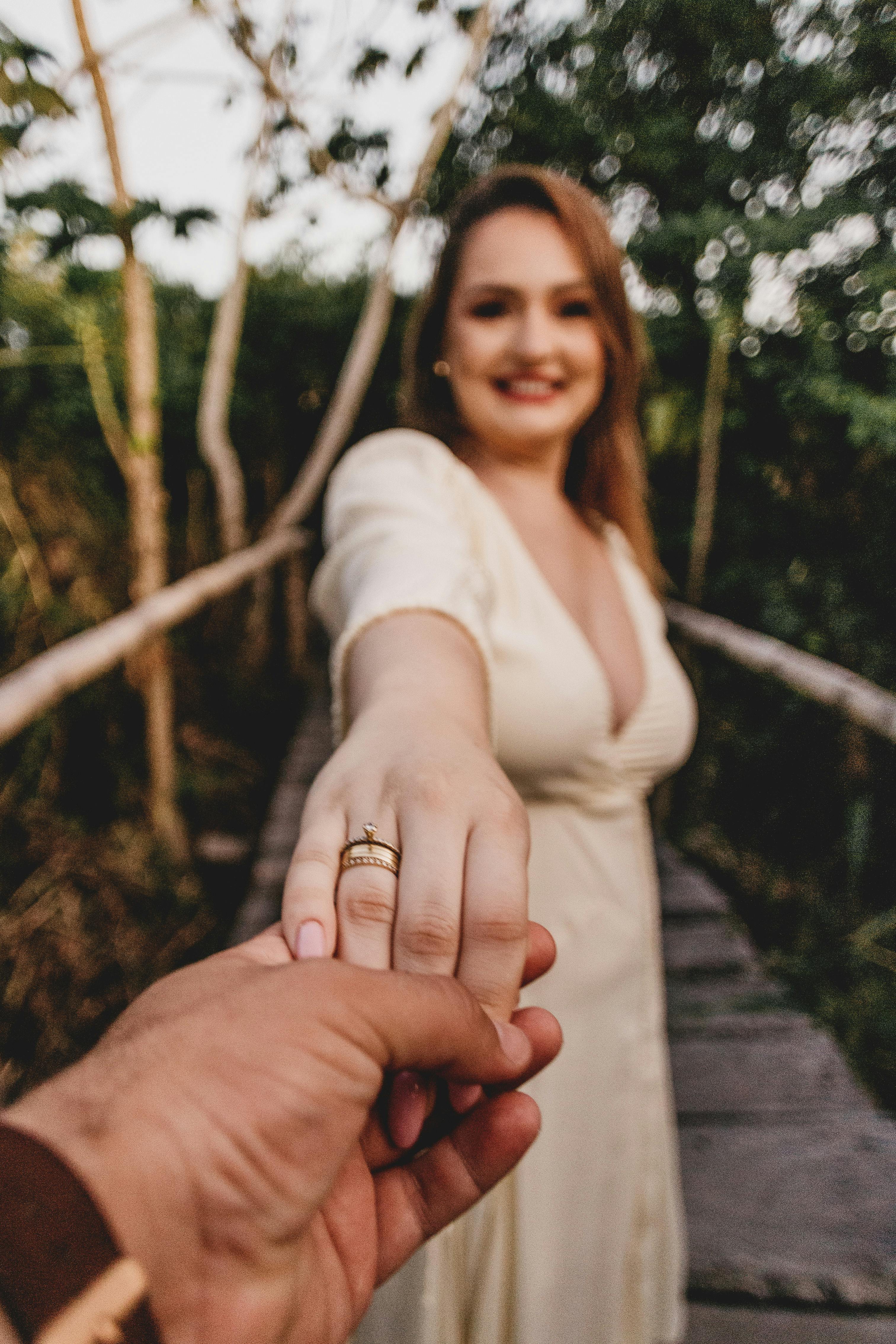 smiling elegant wife holding hand of husband