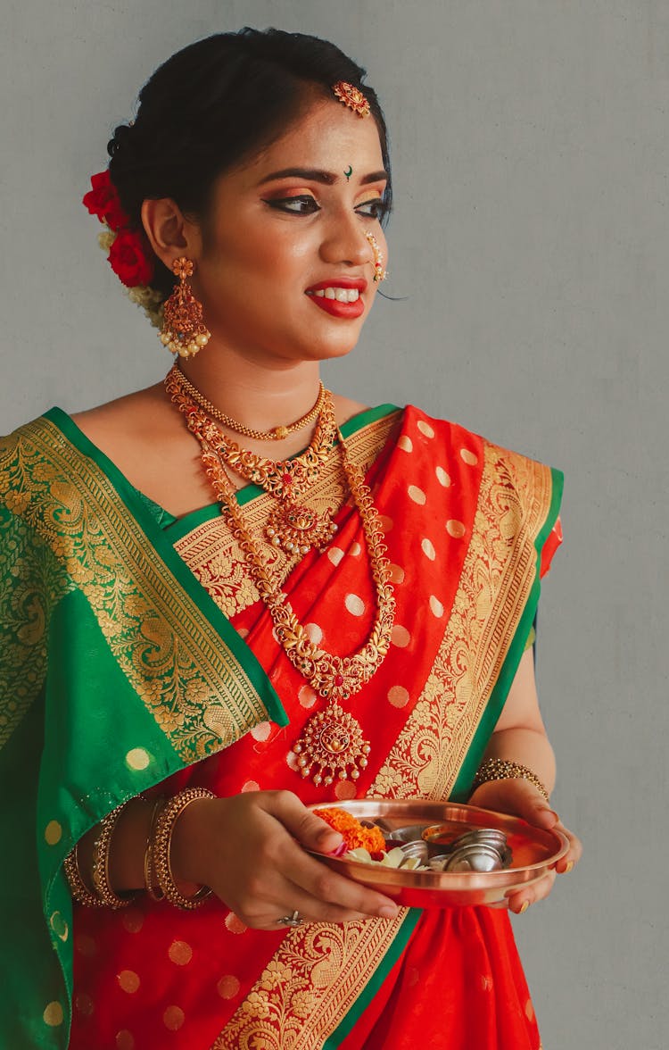 A Woman Wearing Traditional Clothing Holding A Plate