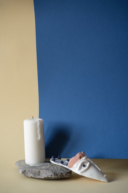 蓝色彩绘墙上的白色支柱蜡烛