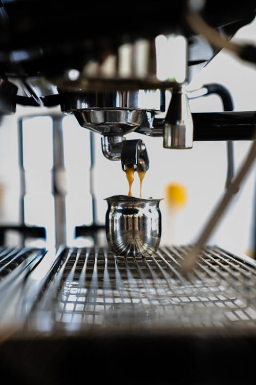 Photo of Espresso Dripping on a Small Stainless Mug