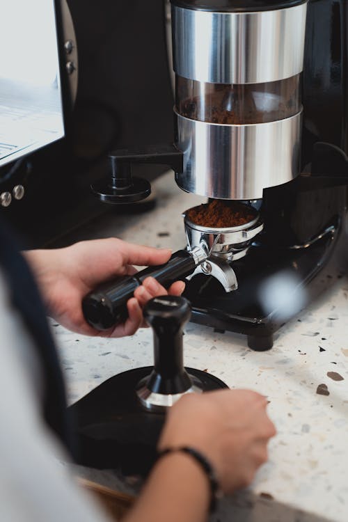 Photo of Person Getting Ground Coffee from Coffee Grinder