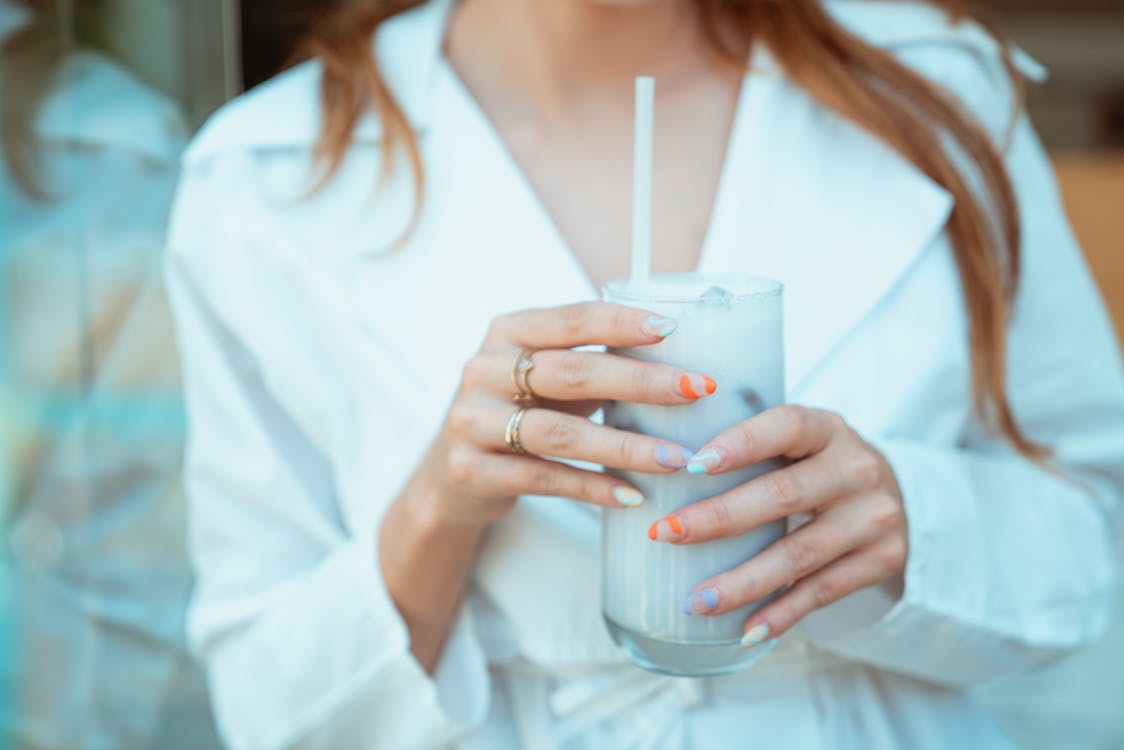 Free A Woman Holding a Drinking Glass with Straw Stock Photo