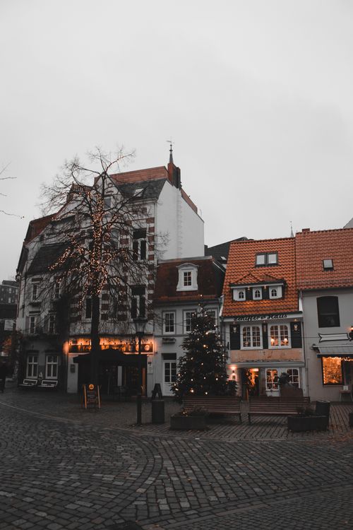 Free Festive European street with Christmas lights and decorations on a cloudy day. Stock Photo