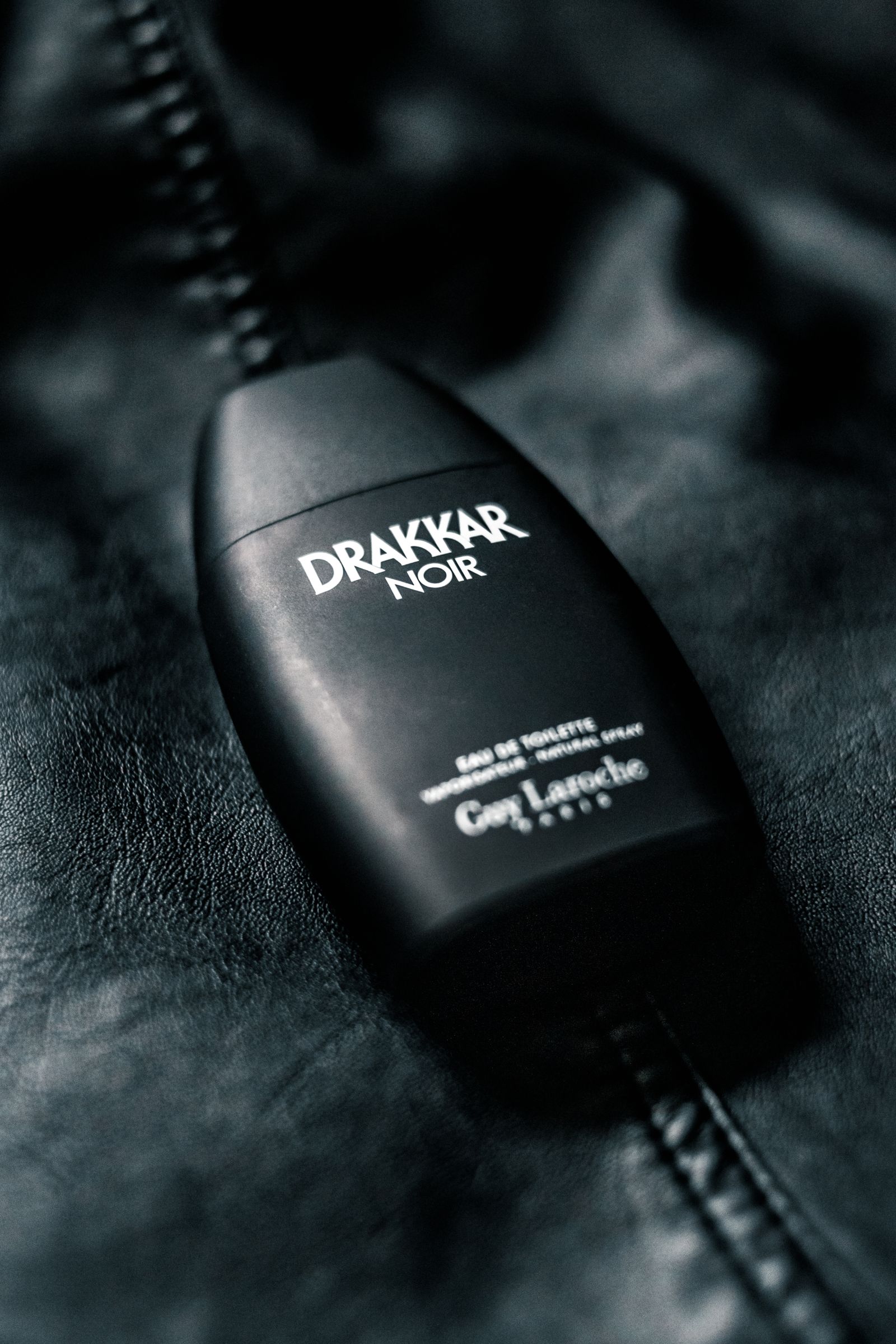 Black masculine perfume bottle on dark surface
