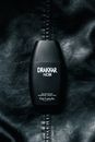 Black bottle of male perfume on dark background