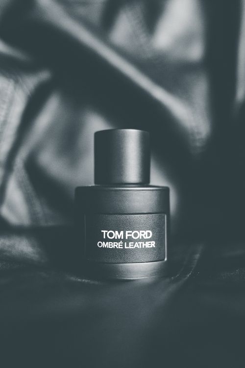 Free Closeup of black plastic bottle with expensive perfume placed on black leather surface Stock Photo
