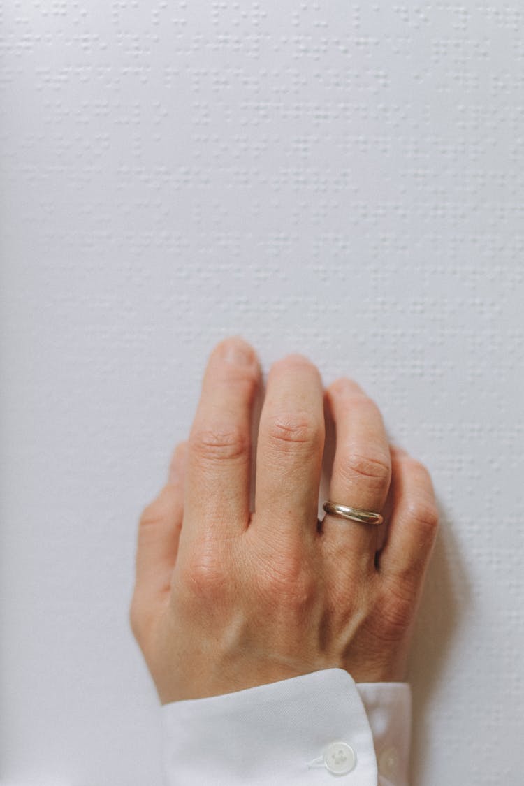 A Hand Touching A Braille Book