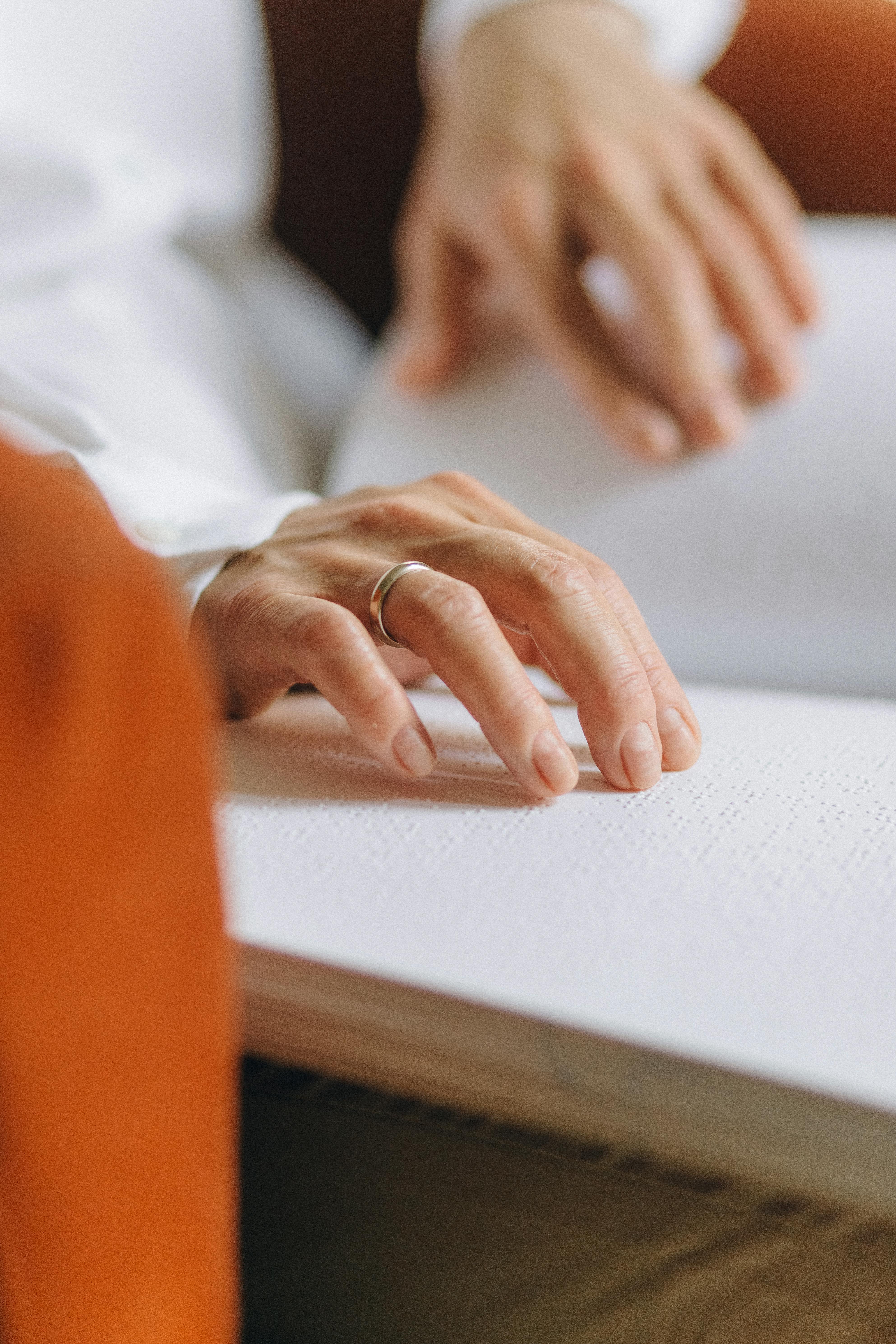 close up shot of a person touching braille book