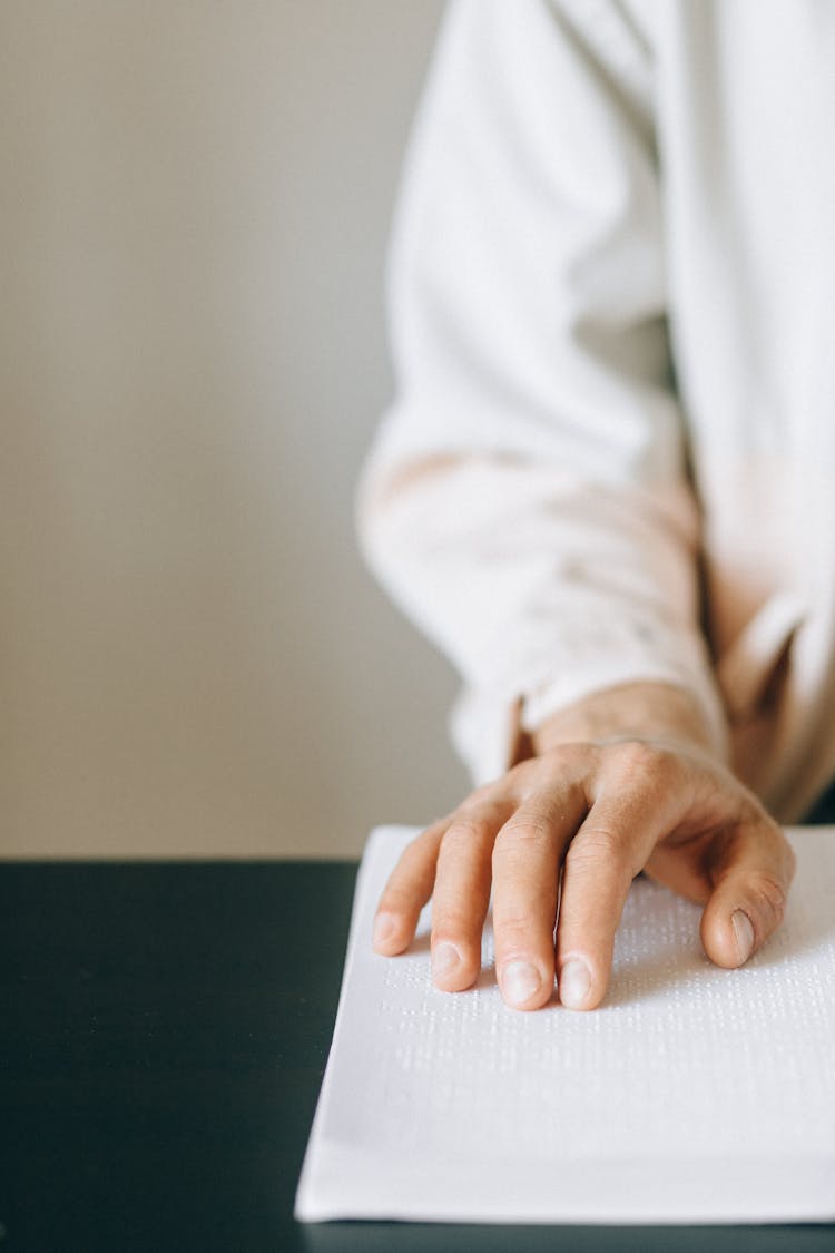 Hand Touching A Braille Book