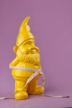 Vibrant yellow gnome figurine wrapped with a tape measure against a purple backdrop.