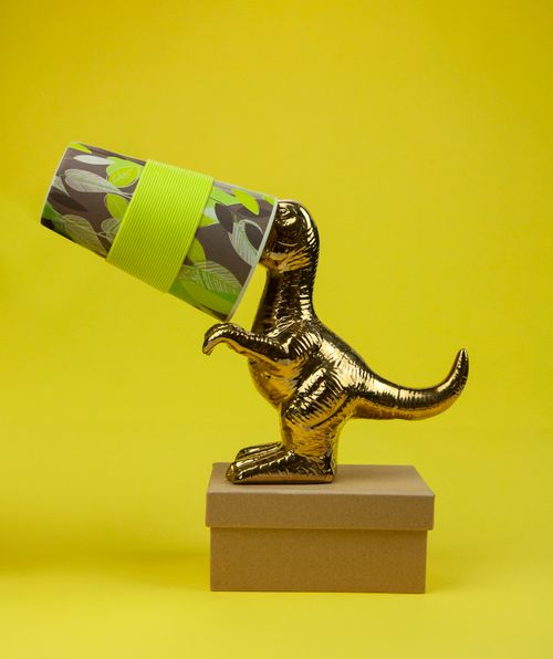 Free Composition of small golden dinosaur toy with colorful paper cup on cardboard box on yellow background Stock Photo