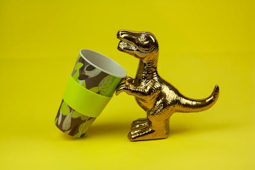 Souvenir dinosaur drinking from mug