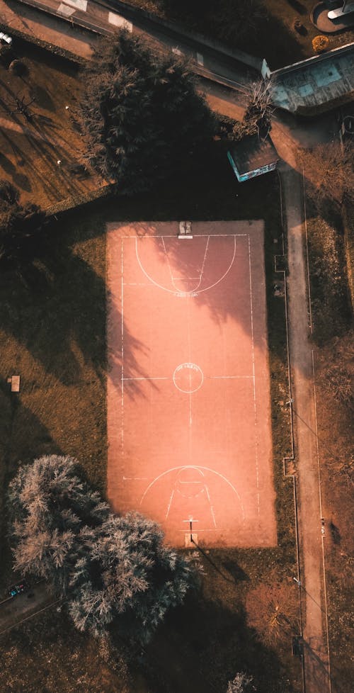 Brown Basketball Court Near the Trees