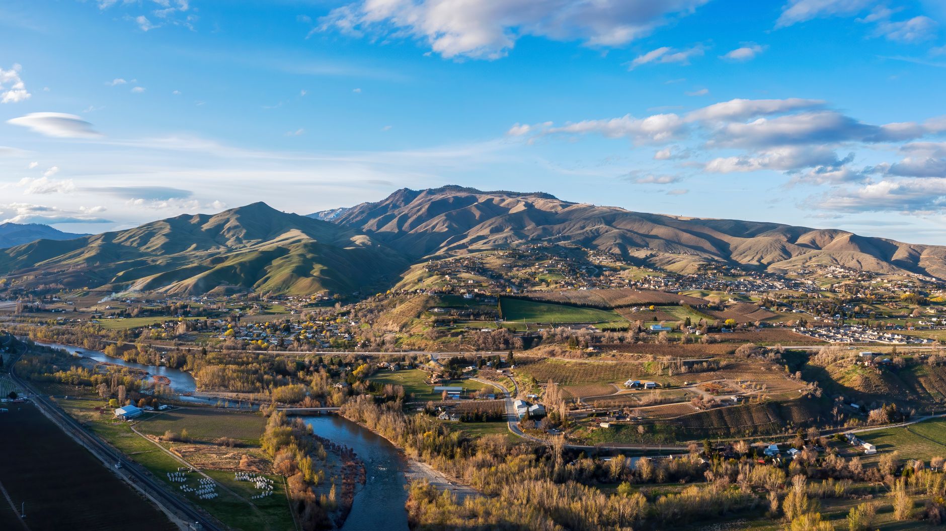 A breathtaking aerial view of the Sunnyslope landscape with lush fields and majestic mountains.