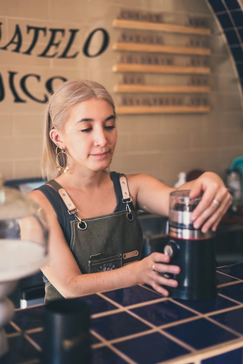 Photo of Barista Using Coffee Grinder