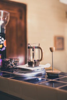 A sleek French press on a cozy cafe countertop, ideal for coffee lovers.