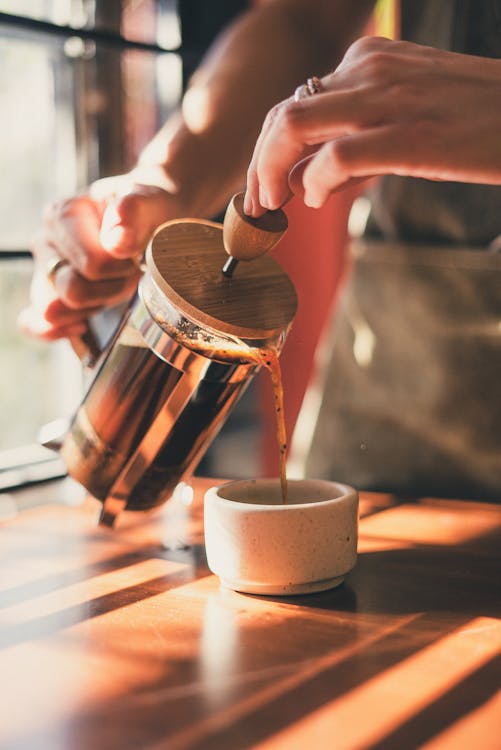 Free Photo of Person Pouring Brewed Coffee on Ceramic Mug Stock Photo