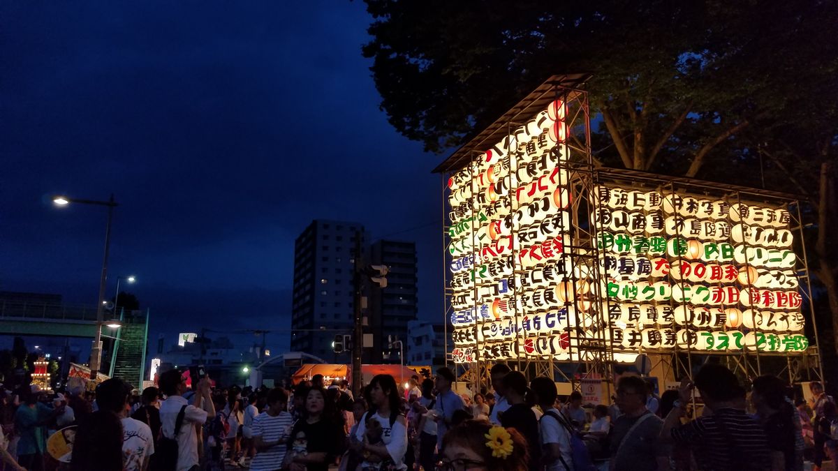 Vibrant night scene of a Japanese summer festival with rows of glowing illuminated lanterns, capturing the energy of matsuri like Aomori Nebuta