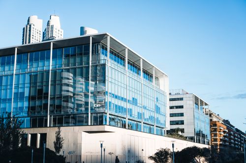 Free Low-angle view of a modern glass facade building in Buenos Aires' vibrant urban landscape. Stock Photo