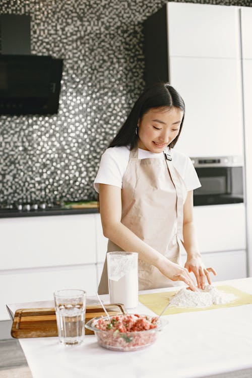 Free A Woman in Apron Preparing Ingredients in the Kitchen Stock Photo