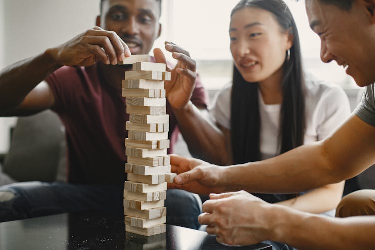 A Group Of Friends Playing Jenga