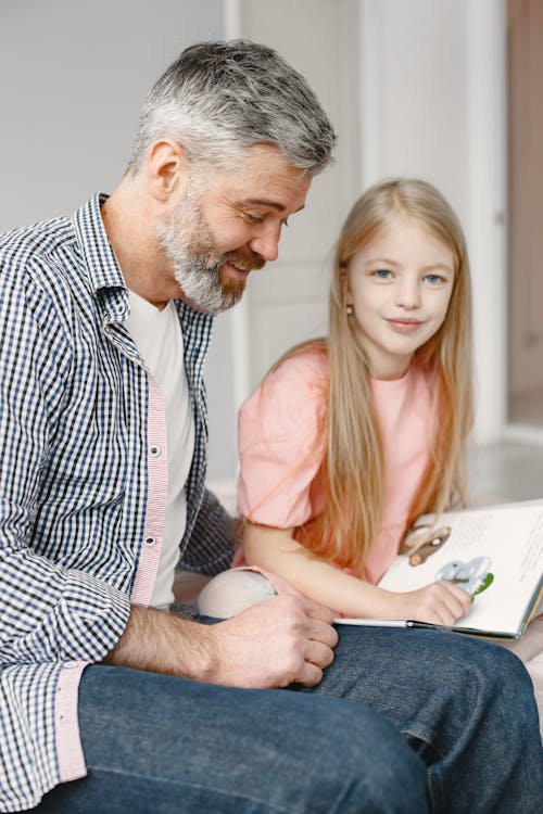 Girl Reading a Book with Her Dad