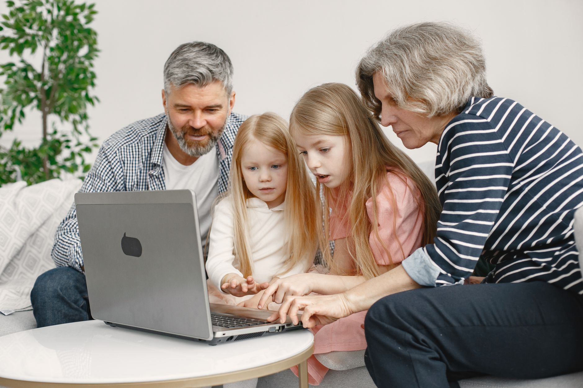 Multigenerational Vacation Planning Without Overbooking Family members of different ages enjoy quality time together while browsing on a laptop.