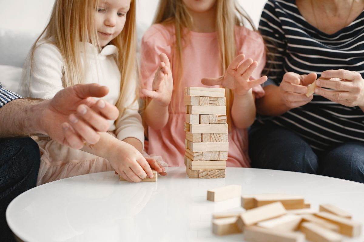 Familia jugando a un juego de mesa juntos en un salón luminoso