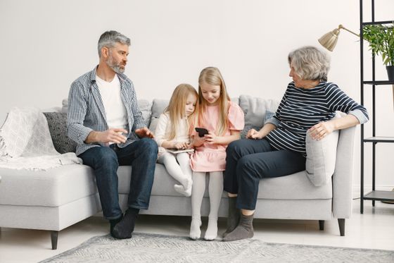 A family laughing together on a cosy living room sofa — photo by Gustavo Fring on Pexels