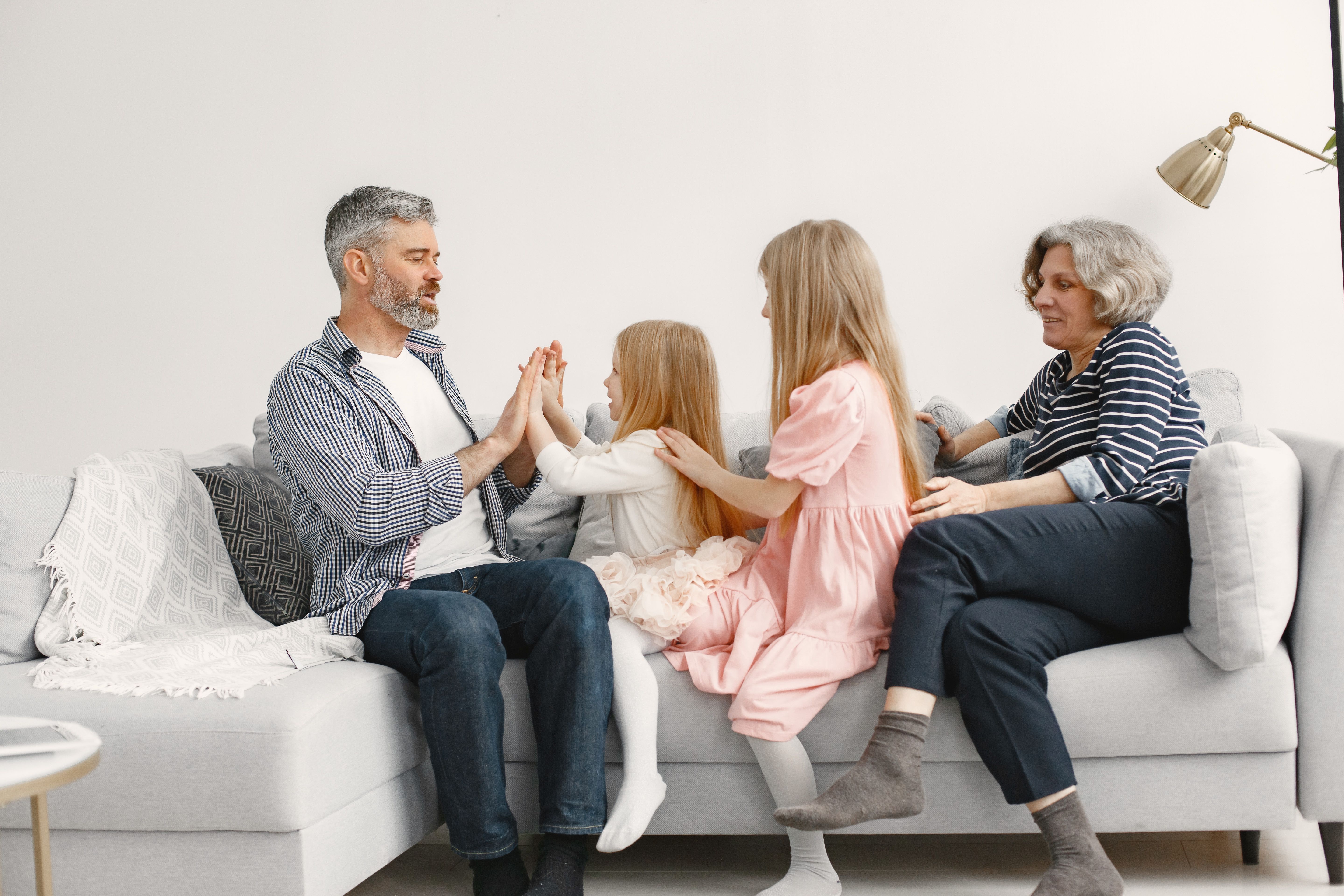 A joyful family spends quality time together, playing and bonding on a cozy sofa.
