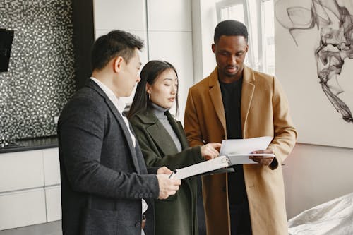 Free People Having Conversation while Holding Documents Stock Photo